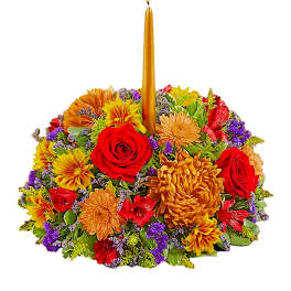 Colorful floral centerpiece with a tall gold candle in the middle