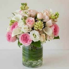 Pink and white roses with calla lilies in a glass vase