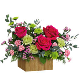 Pink roses and carnations in a wooden box with green accents