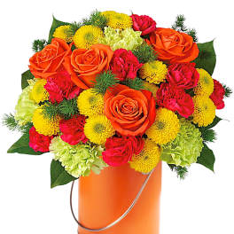Mixed bouquet of orange roses, yellow mums, and pink carnations in an orange bucket