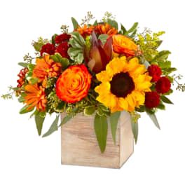 Bright mixed bouquet in a wooden cube vase