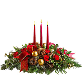 Christmas centerpiece with red candles, pinecones, and ribbon