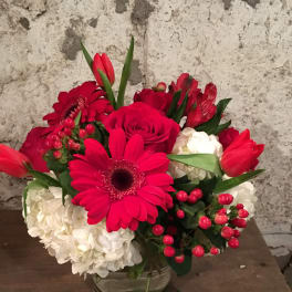 Red and white flower arrangement in a clear glass vase