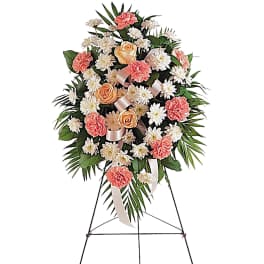 Standing floral spray with pink carnations, white daisies, and peach roses
