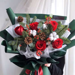 Bouquet of red roses with pinecones and cotton in dark green wrap