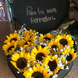 Heart-shaped box of sunflowers with a handwritten message on the lid