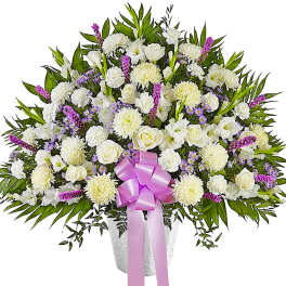 White floral spray with a pink ribbon in a vase
