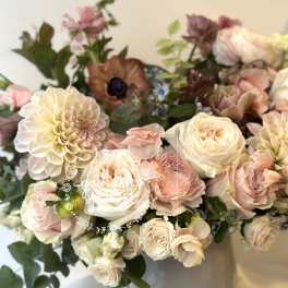 Bouquet of blush and cream flowers in a white vase