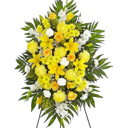 Yellow and white funeral spray on a standing easel