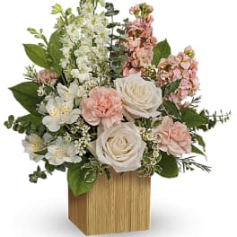 Pink and white floral arrangement in a wooden cube vase