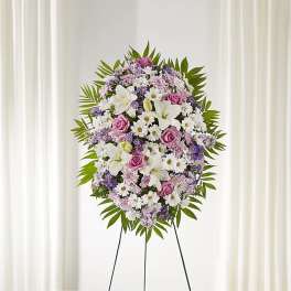 Standing floral wreath with white lilies, pink roses, and daisies