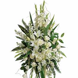 Tall white floral standing spray with lilies and roses on a stand