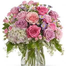 Pink and lavender rose bouquet in a clear glass vase