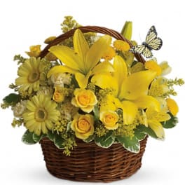 Yellow flowers arranged in a wicker basket with a butterfly decoration