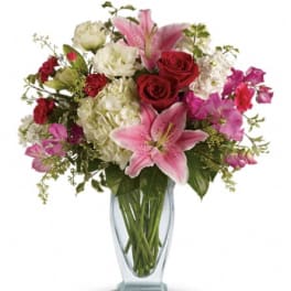 Pink lilies and red roses in a clear glass vase