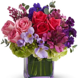 Bouquet of pink and red roses in a purple glass vase