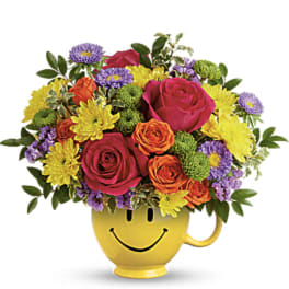 Colorful bouquet in a yellow smiley-face mug