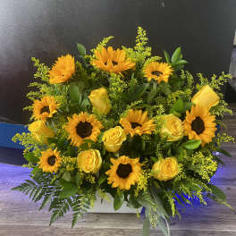 Yellow sunflowers and roses in a low rectangular arrangement