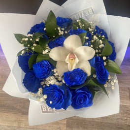 Blue roses with a white orchid in wrapped bouquet