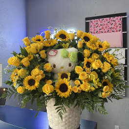 Yellow rose and sunflower arrangement with a Hello Kitty plush in a basket