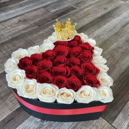 Heart-shaped box of red and white roses with a gold crown topper