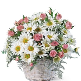 Pink roses and white daisies in a woven basket