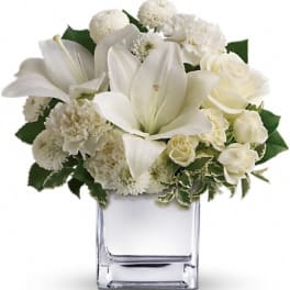 White floral arrangement in a clear square vase