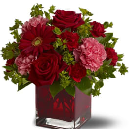 Red roses and carnations in a square glass vase