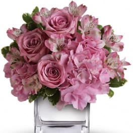 Pink roses and alstroemeria arranged in a clear square vase