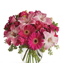 Pink lilies and gerbera daisies in a clear glass vase