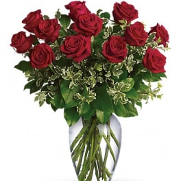 Red roses arranged in a clear glass vase