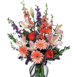 Mixed bouquet of lilies, roses, and daisies in a glass vase