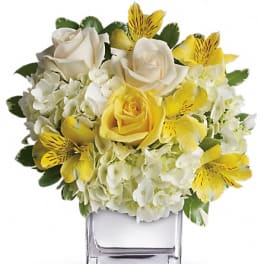Yellow and white bouquet in a clear square vase