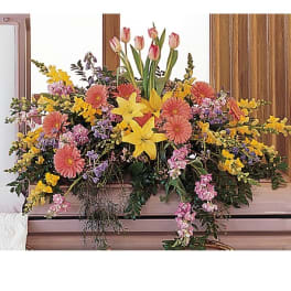 Large mixed floral arrangement with pink tulips, yellow lilies, and gerbera daisies