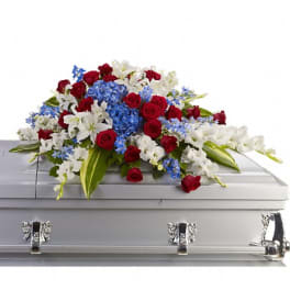 Red, white, and blue floral spray on a silver casket