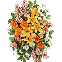 Standing floral spray with yellow lilies, orange daisies, and pink carnations
