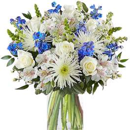 White and blue mixed bouquet in a clear glass vase