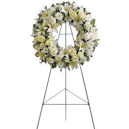 White floral wreath on a black easel stand
