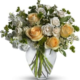 Bouquet of cream and white roses in a clear glass vase
