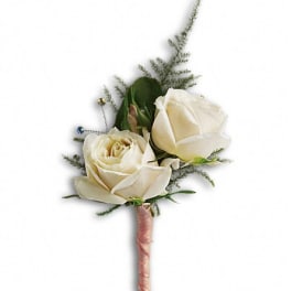 White rose boutonniere with greenery and a pink ribbon-wrapped stem