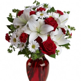 Red and white flower bouquet in a red glass vase
