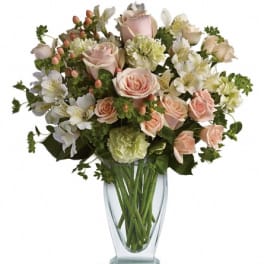 Pink roses and white flowers in a clear glass vase