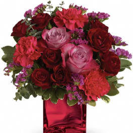 Red and pink roses in a red glass vase