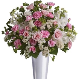 Pink and white floral arrangement in a tall silver vase