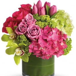 Pink and red roses with hydrangeas in a green glass vase