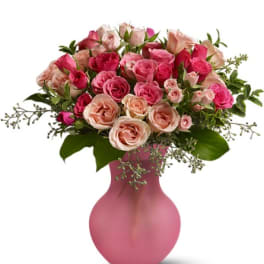 Pink and peach roses arranged in a pink vase
