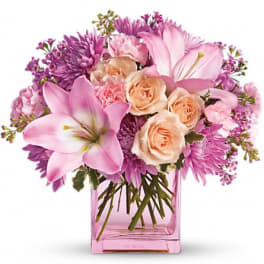 Pink and peach flower bouquet in a pink glass vase