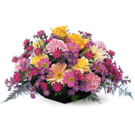 Mixed bouquet of pink, purple, and yellow flowers in a black container