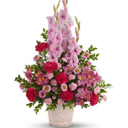 Pink gladiolus and mixed pink flowers in a woven basket