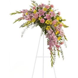 Pink and yellow floral standing spray on a white easel